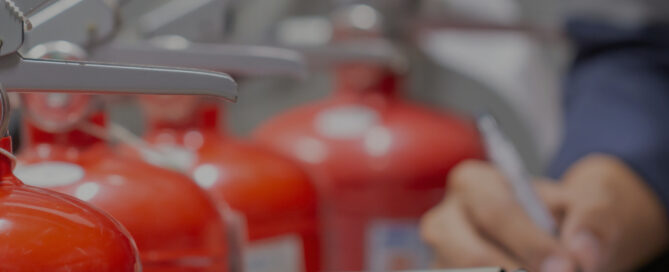 Close-up of fire extinguishers being inspected and documented, representing fire safety maintenance. The text reads, "Fire Hydrants and Extinguishers: A Complete Guide to Maintenance and Inspection," with the Interstate Fire Protection logo at the bottom right.